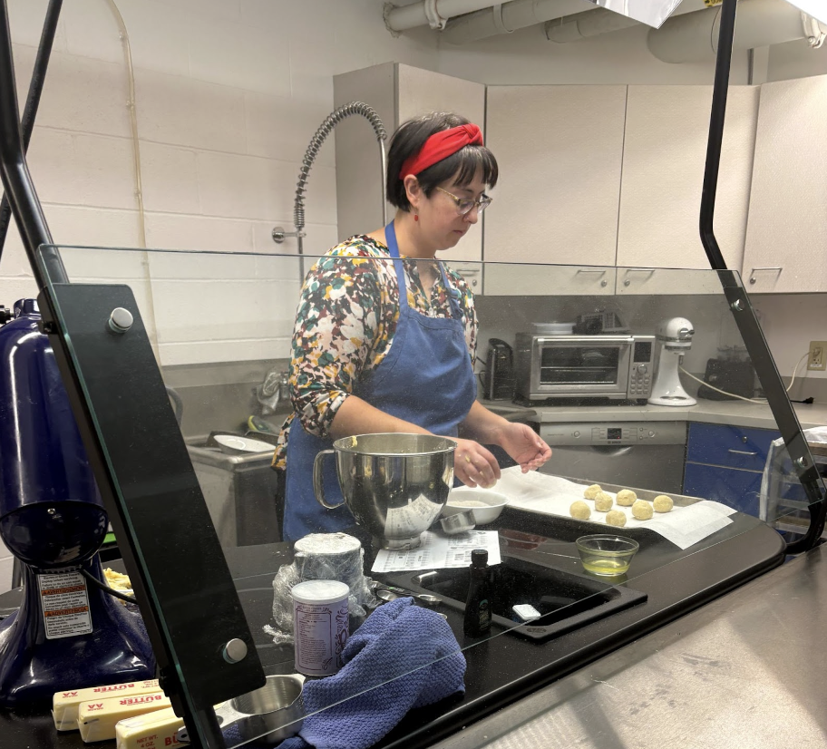 Highlands High School culinary teacher Kelsey Sentney rolls her dough on a cookie sheet. (Photo from Adalyn Armstrong-Cattani).
